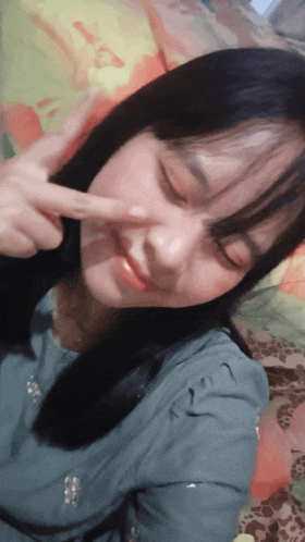 a girl with long black hair is making a funny face