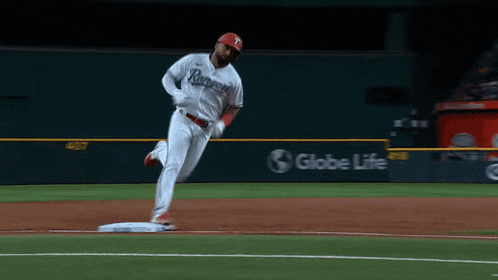 a baseball player in a rangers jersey is running to base