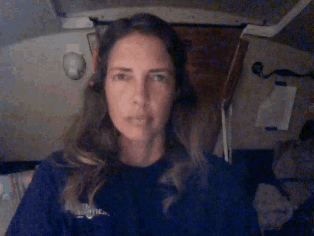 a woman is pointing her finger at something in a dark room