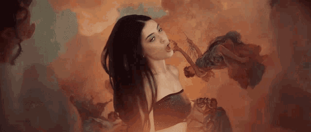 a woman in a black top is surrounded by smoke and smoke coming out of her mouth