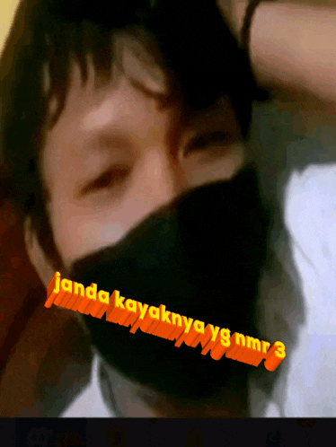 a man wearing a black face mask with the words janda kayaknya yg nmr3 written on it