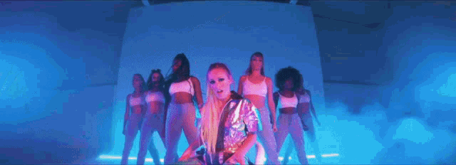 a woman in a sequined jacket is standing in front of two other women