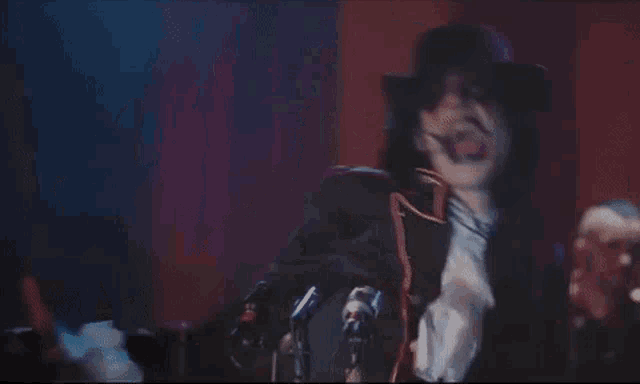 a man in a top hat is dancing on stage .