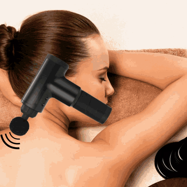 a woman getting a massage with a black massage gun