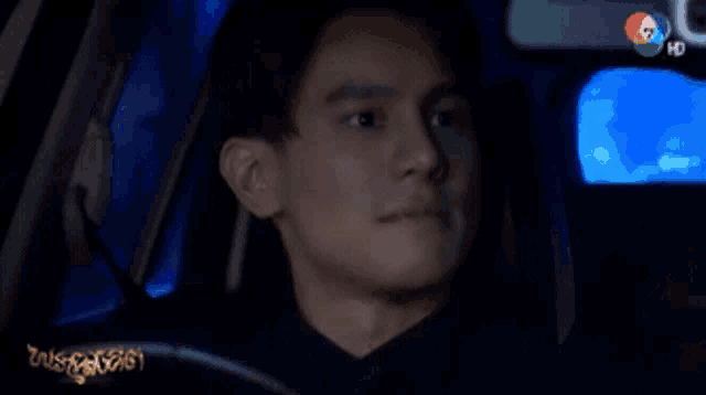 a man is sitting in a car with the number 7 on the bottom right