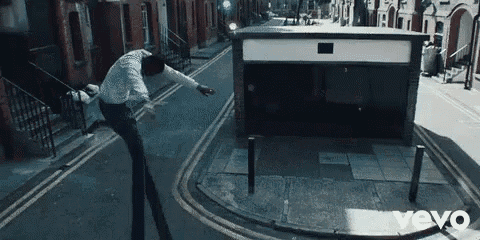 a man is doing a trick on the street in front of a building that says vevo on the bottom