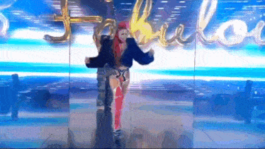 a woman is dancing on a stage in front of a sign that says fabulous
