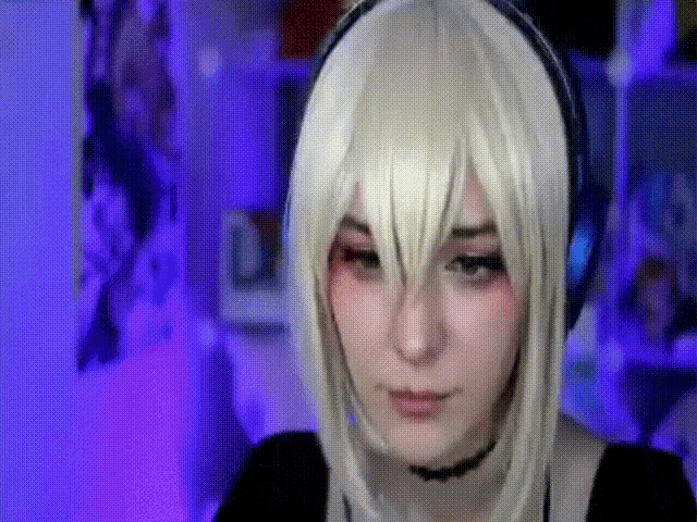 a woman wearing a wig and headphones is looking at the camera