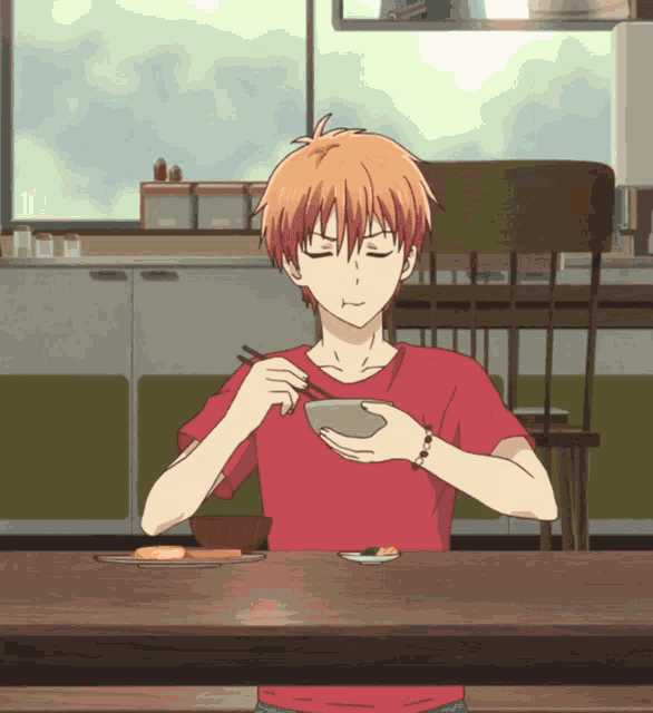 a boy in a red shirt is sitting at a table with chopsticks and a bowl of food