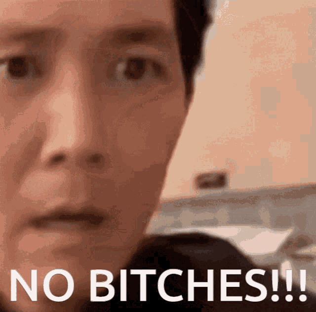 a close up of a man 's face with the words " no bitches " written below it