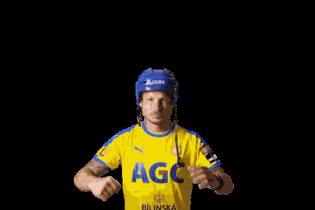 a man wearing a blue helmet and a yellow agc shirt