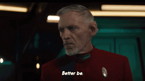 a man in a red uniform says " better be " in a dark room
