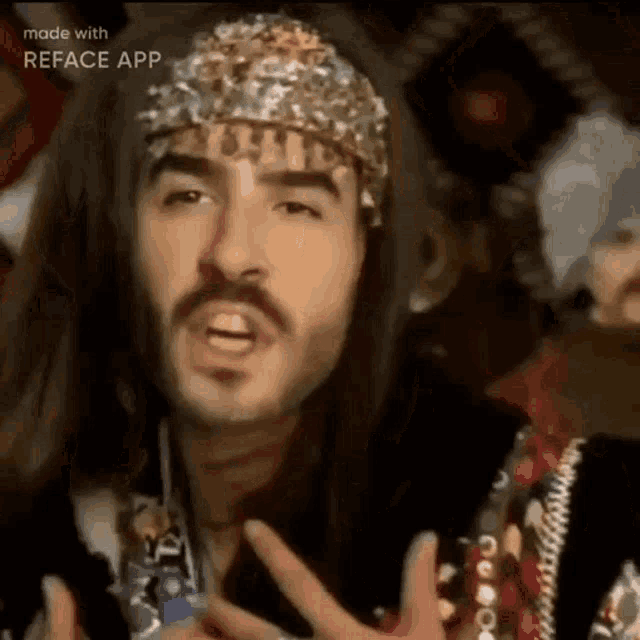 a man with long hair and a mustache is wearing a hat and making a funny face .
