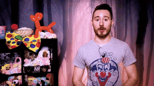 a man wearing a clown shirt stands in front of a shelf with stuffed animals