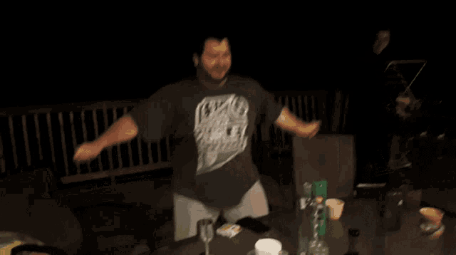 a man wearing a hurley shirt is dancing in a dark room