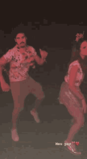a man and woman are dancing in a dark room .