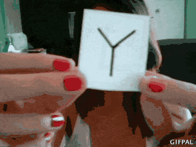 a woman with red nails holds up a card with the letter y on it