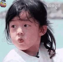 a little girl is making a funny face with her mouth open and her eyes closed .