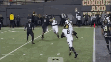 a football game is being played in front of a sign that says conque and prevail