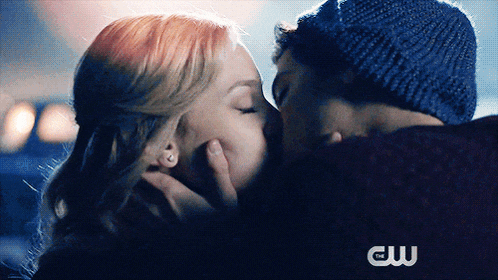 a man and a woman kissing in front of a cw logo