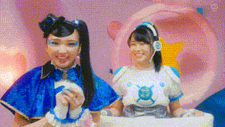 two girls in blue and white costumes are sitting next to each other on a pink background .