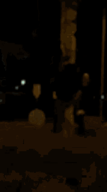 a blurry picture of a person standing under a colorful umbrella in the dark .