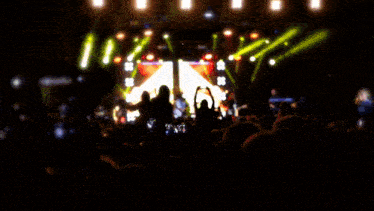 a blurry picture of a crowd at a concert with a red arrow in the middle