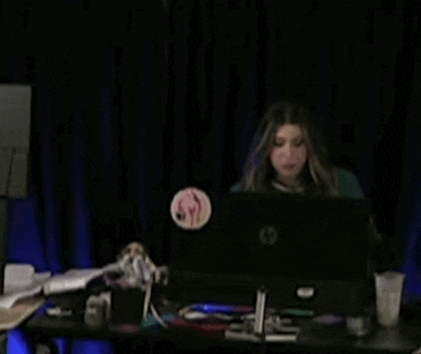 a woman is sitting at a desk in front of a computer monitor .
