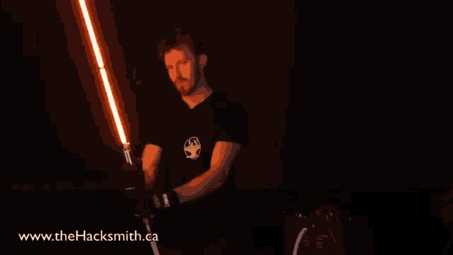 a man holding a light saber with the website www.thehacksmith.ca visible
