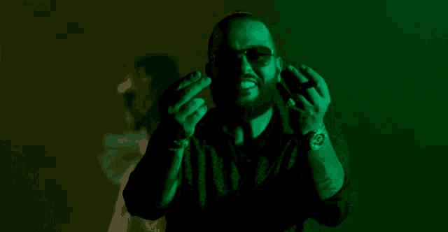 a man with a beard wearing sunglasses and a watch making a funny face