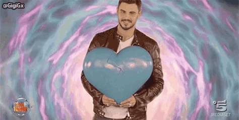 a man is holding a blue heart shaped balloon .