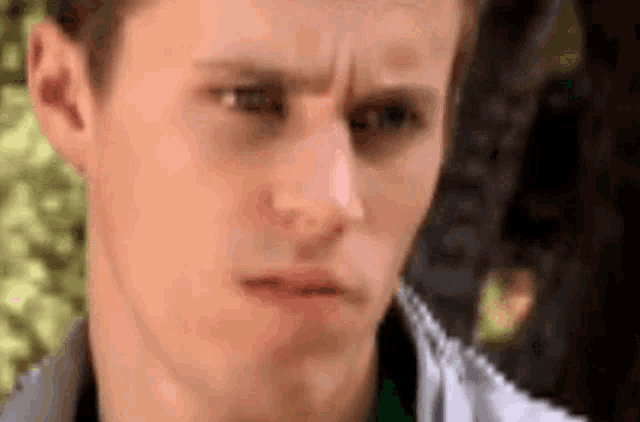 a close up of a young man 's face making a funny face .
