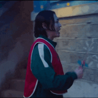 a person wearing a red vest with the number 123 on it is standing in front of a brick wall