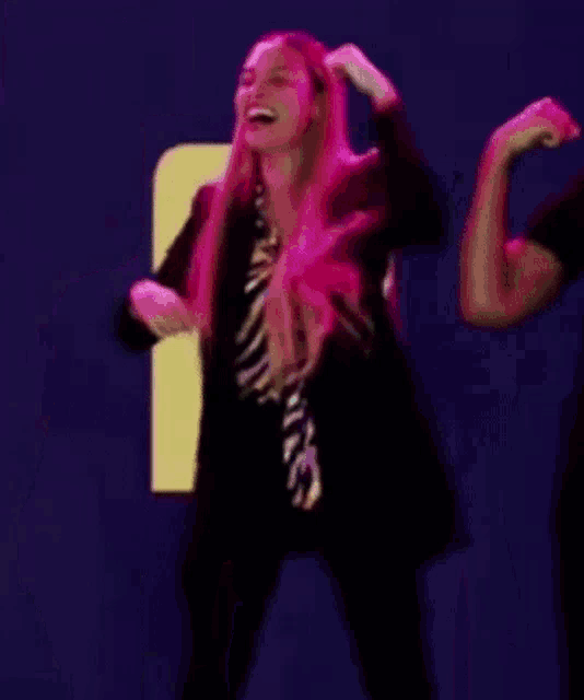 a woman with pink hair is dancing with a man in a black shirt