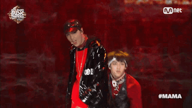 a man in a red shirt is standing next to a man in a black jacket at a mnet music awards event