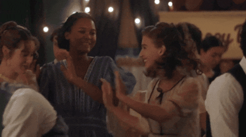 a group of women are dancing together in a room with a sign that says ' a ' on it