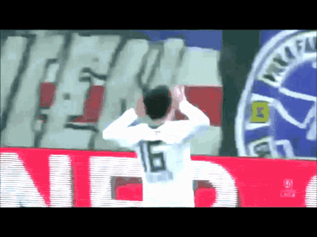 a soccer player wearing a white jersey with the number 16 on the back