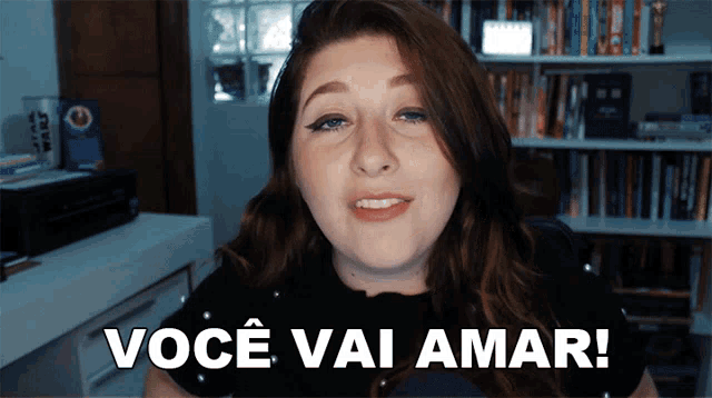 a woman says voce vai amar in front of a bookshelf