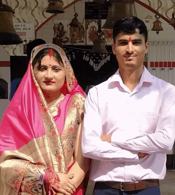 a man and a woman are posing for a picture in front of a sign that says ' shree ram ' on it