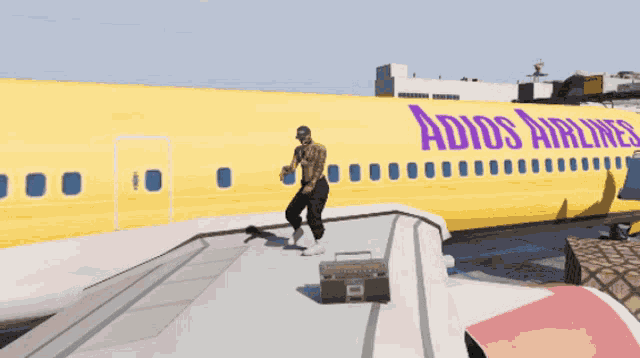 a man is standing on the wing of a yellow adios airlines plane