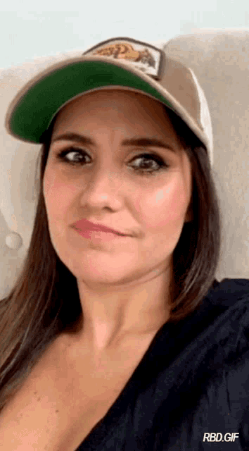 a woman wearing a hat with the word rbd on the bottom right