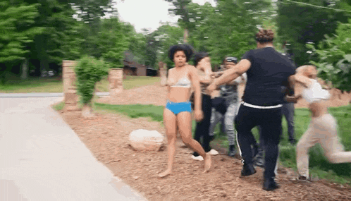 a woman in a bikini is being pulled by a group of people .