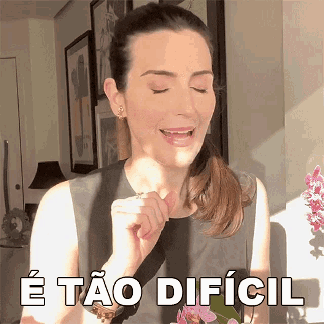 a woman with her eyes closed and the words e tao dificil behind her
