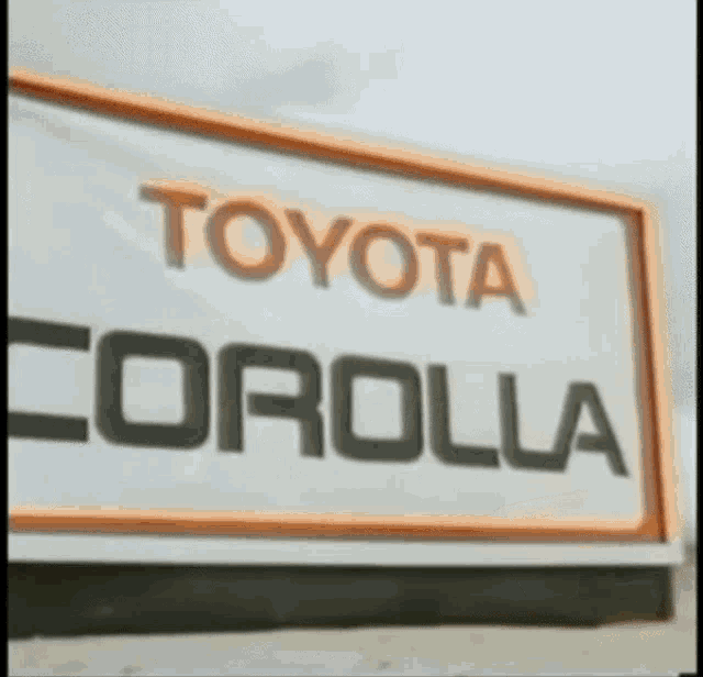 a sign that says toyota corolla in black and orange