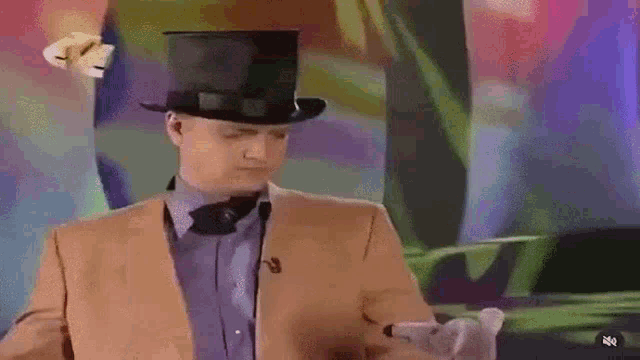a man in a top hat and bow tie is holding a toy .