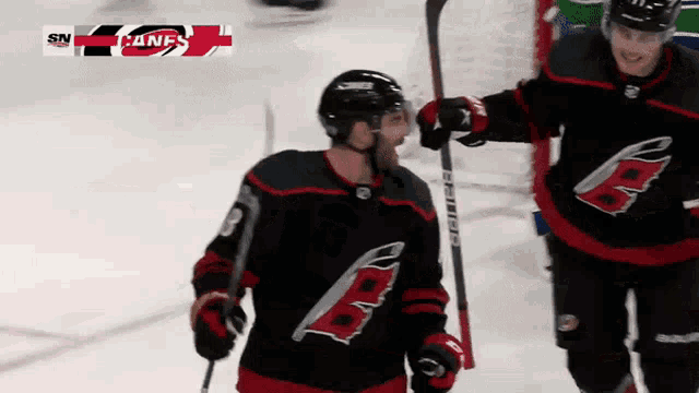a hockey player with the letter b on his jersey is holding a hockey stick