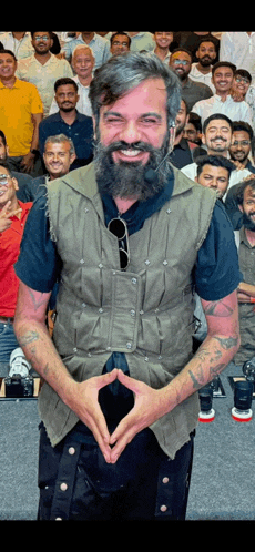 a man with a beard is standing in front of a crowd of people .