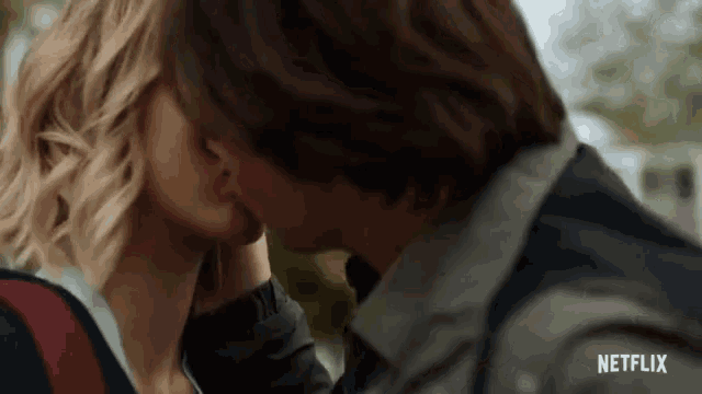 a man and a woman are kissing in a close up of a netflix ad .