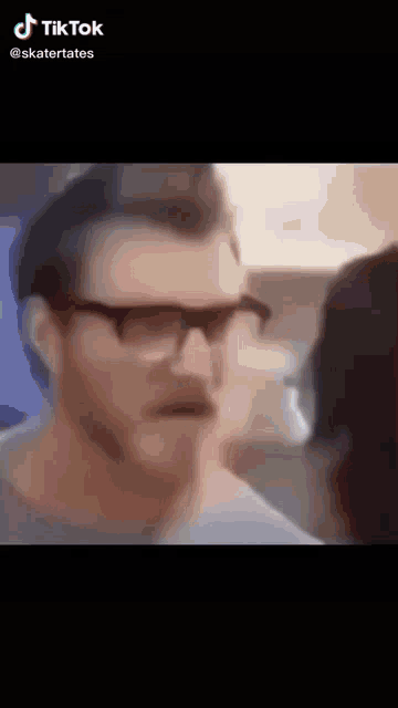 a close up of a man wearing glasses and a mustache .