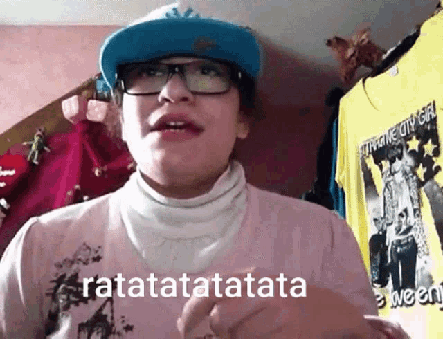 a person wearing glasses and a hat says ratatatatatatata